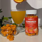 Habitual Gurkmeja Gummies livsstilsbild — burk med apelsinjuice och färska apelsiner för leder och inflammation
